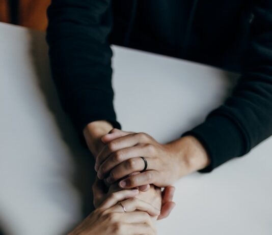 사회적지지가 주는 정신 건강 증진 person in black long sleeve shirt holding babys feet