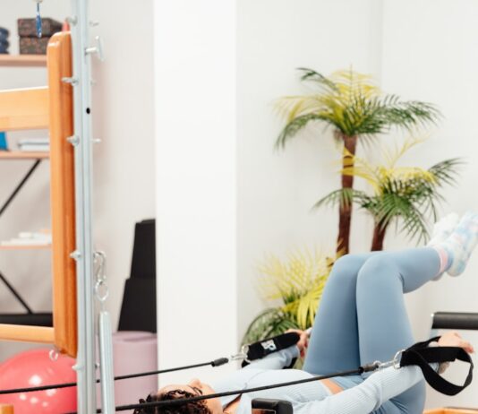 필라테스 기초 동작으로 일상 운동 a woman laying on a bench in a gym