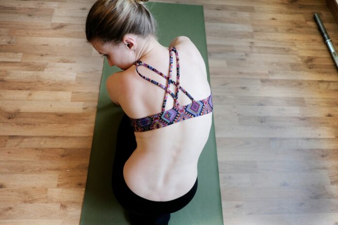 Photo by GMB Fitness woman in purple sports bra doing yoga