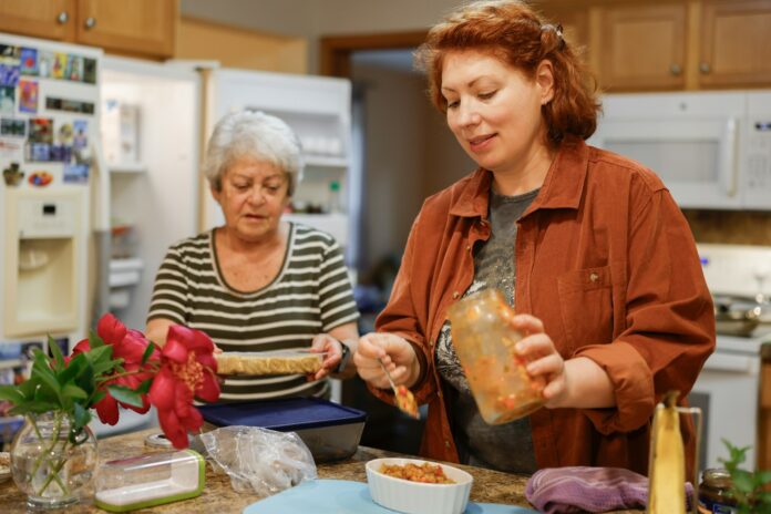 Photo by Land O'Lakes, Inc. Two women preparing food in a kitchen.