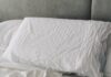 숙면은 습관에서 시작된다…현대인의 건강을 지키는 새로운 수면 루틴 A rumpled white duvet and pillows on a bed.