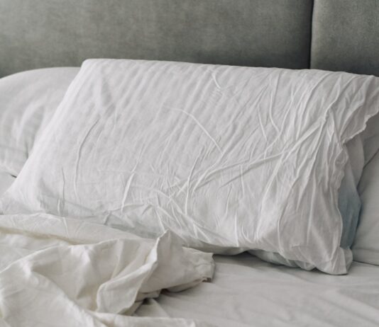 숙면은 습관에서 시작된다…현대인의 건강을 지키는 새로운 수면 루틴 A rumpled white duvet and pillows on a bed.