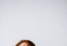 “만성피로, 단순 피로 넘어 ‘현대인의 질환’으로… 맞춤형 관리가 핵심” a woman sitting on a couch holding her hands to her face