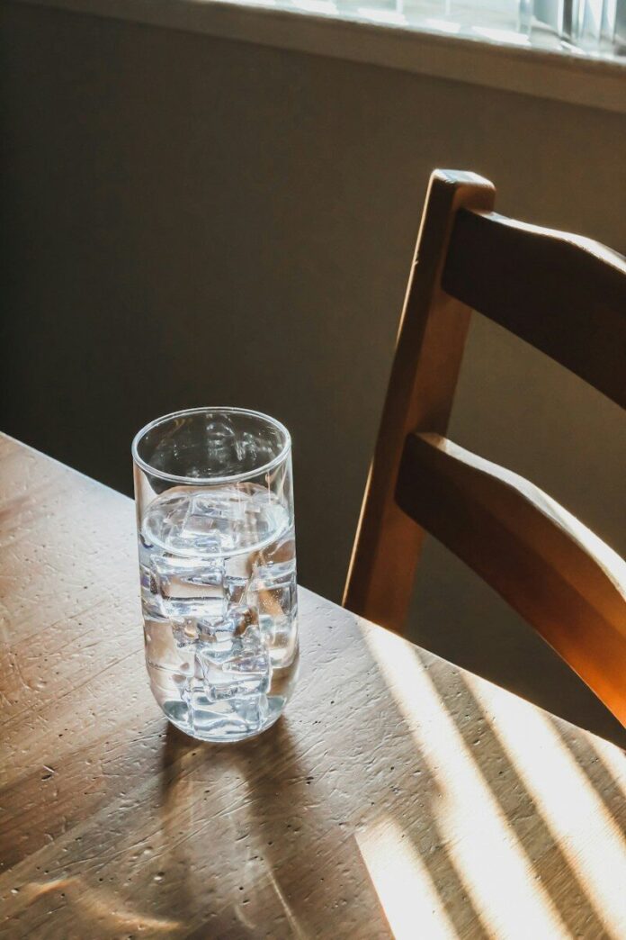 Photo by Giorgio Trovato clear drinking glass on brown wooden table